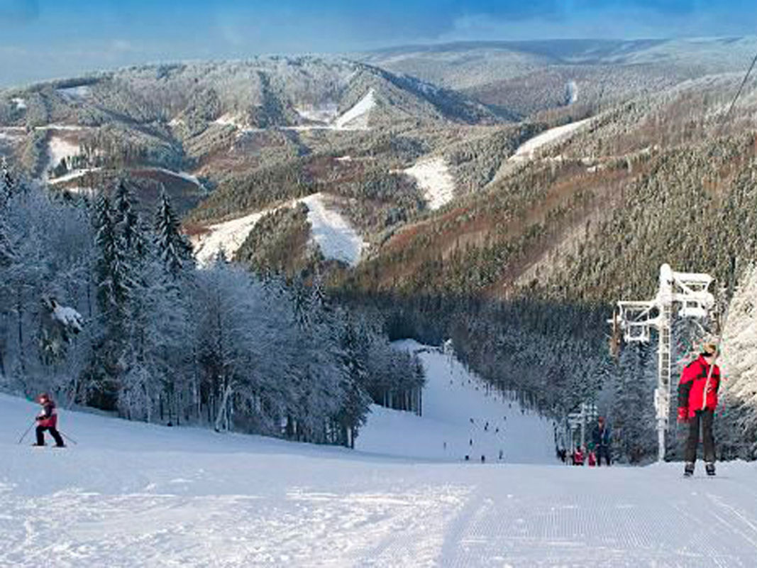 Skalka in Slovakia - a group of people skiing down a mountain.