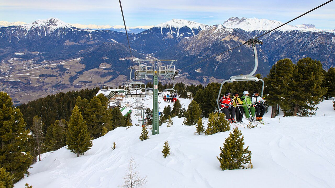 Alpe Cermis – Cavalese in Italy - a ski lift going up a snowy mountain.