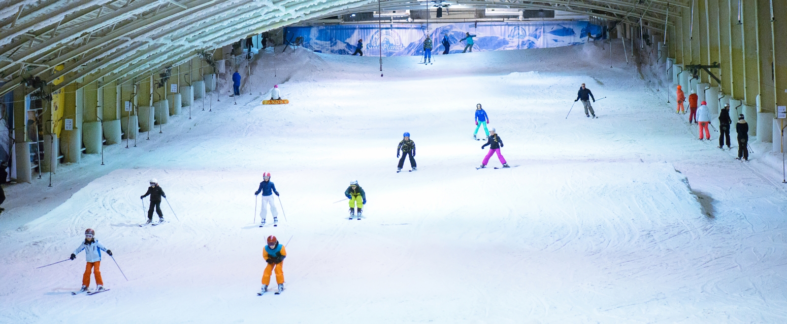 SnowWorld Amsterdam in Netherlands - a group of people skiing down a snowy slope.