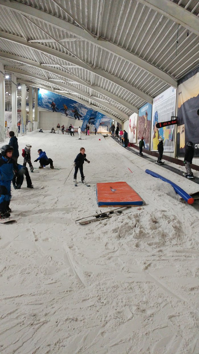 SnowWorld Amsterdam in Netherlands - a group of people skiing down a snow covered slope.
