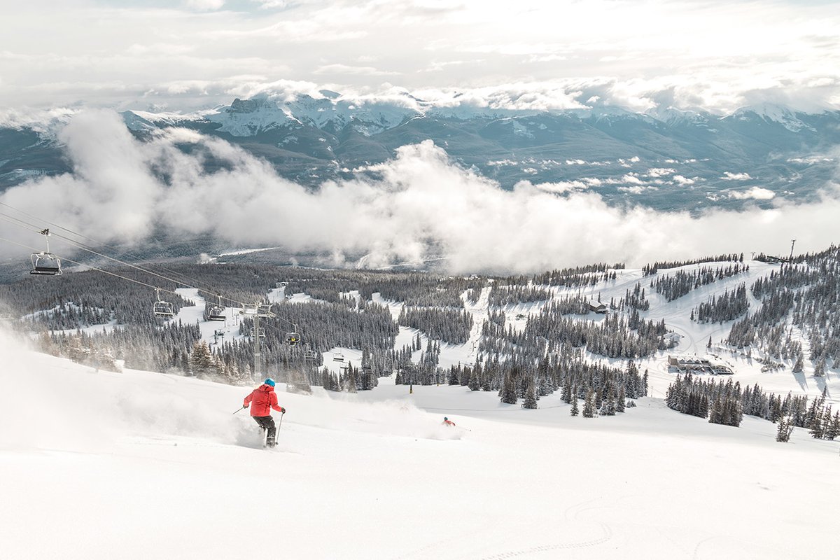 Marmot Basin in Canada - a person skiing down a snowy slope in the mountains.