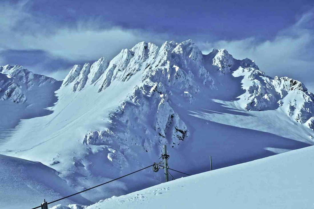 Mount Olympus in New Zealand - a ski slope with snow covered mountains in the background.