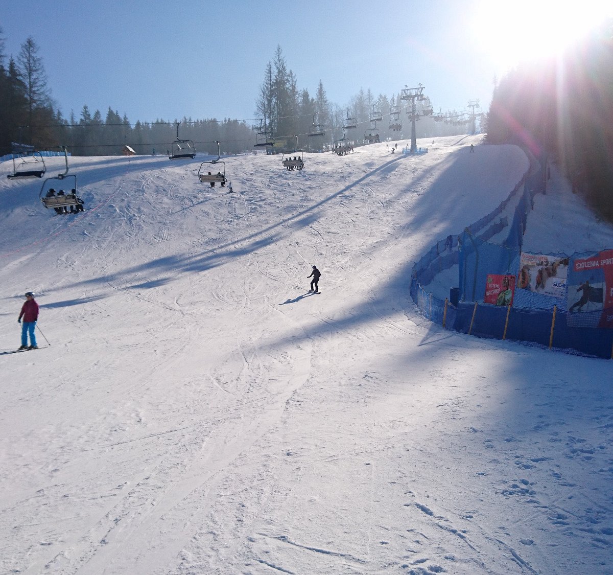 Suche in Poland - a group of people skiing down a snowy hill.