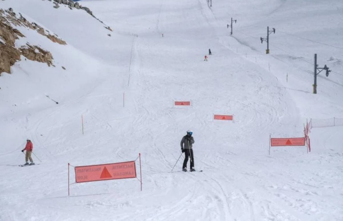 L'Orient in Switzerland - a group of people skiing down a snowy slope.