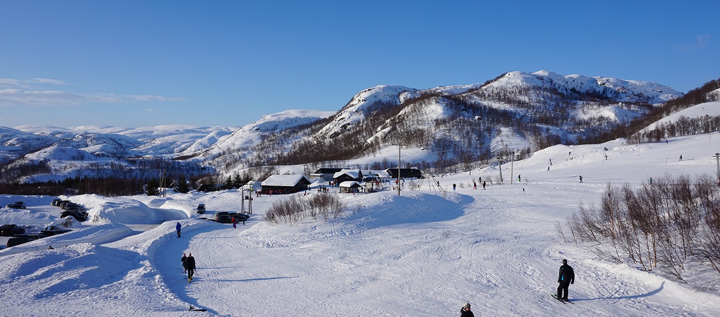 Fidjeland in Norway - a group of people skiing down a snow covered slope.