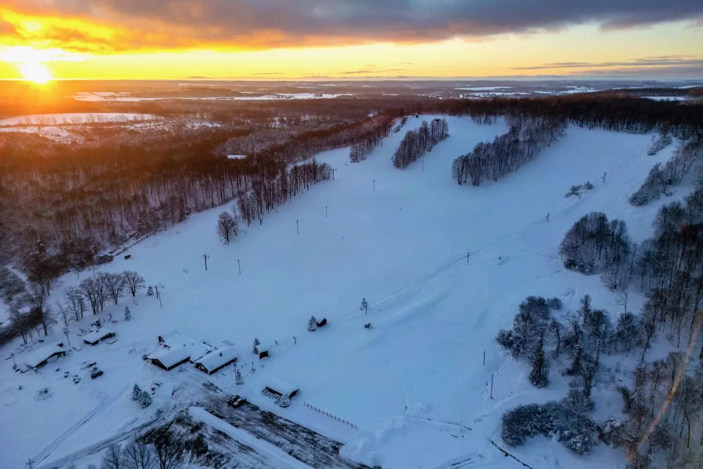 Dry Hill in USA - an aerial view of a snowy landscape at sunset.