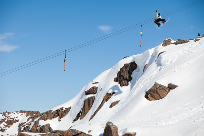 A snowboarder navigating a well-groomed track with a buoyant air of excitement in the chilly peaks of Ben Lomond, Tasmania.