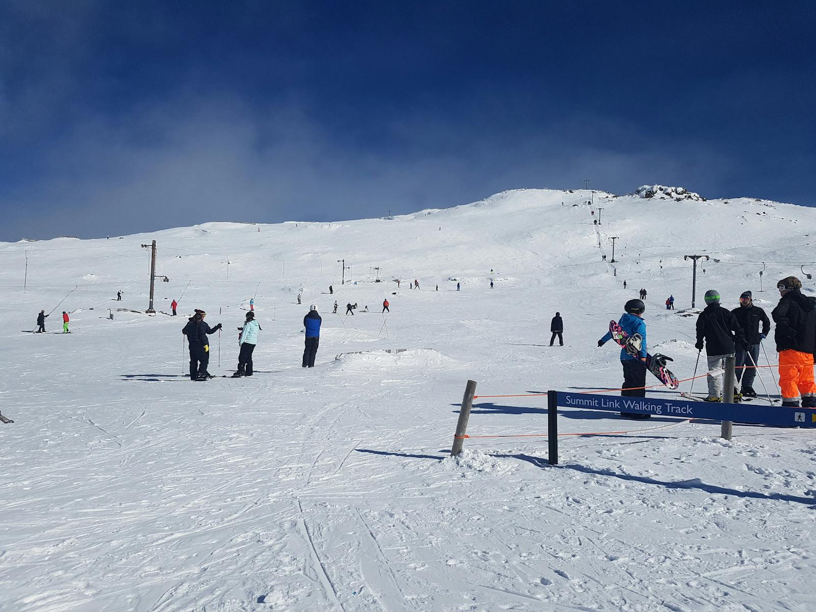 A scenic view of Ben Lomond in Tasmania Australia showcasing a chalet and ski resort at the heart of a bustling winter sports scene. Skiers enjoying on the snowy terrain creating a vibrant winter sports atmosphere.