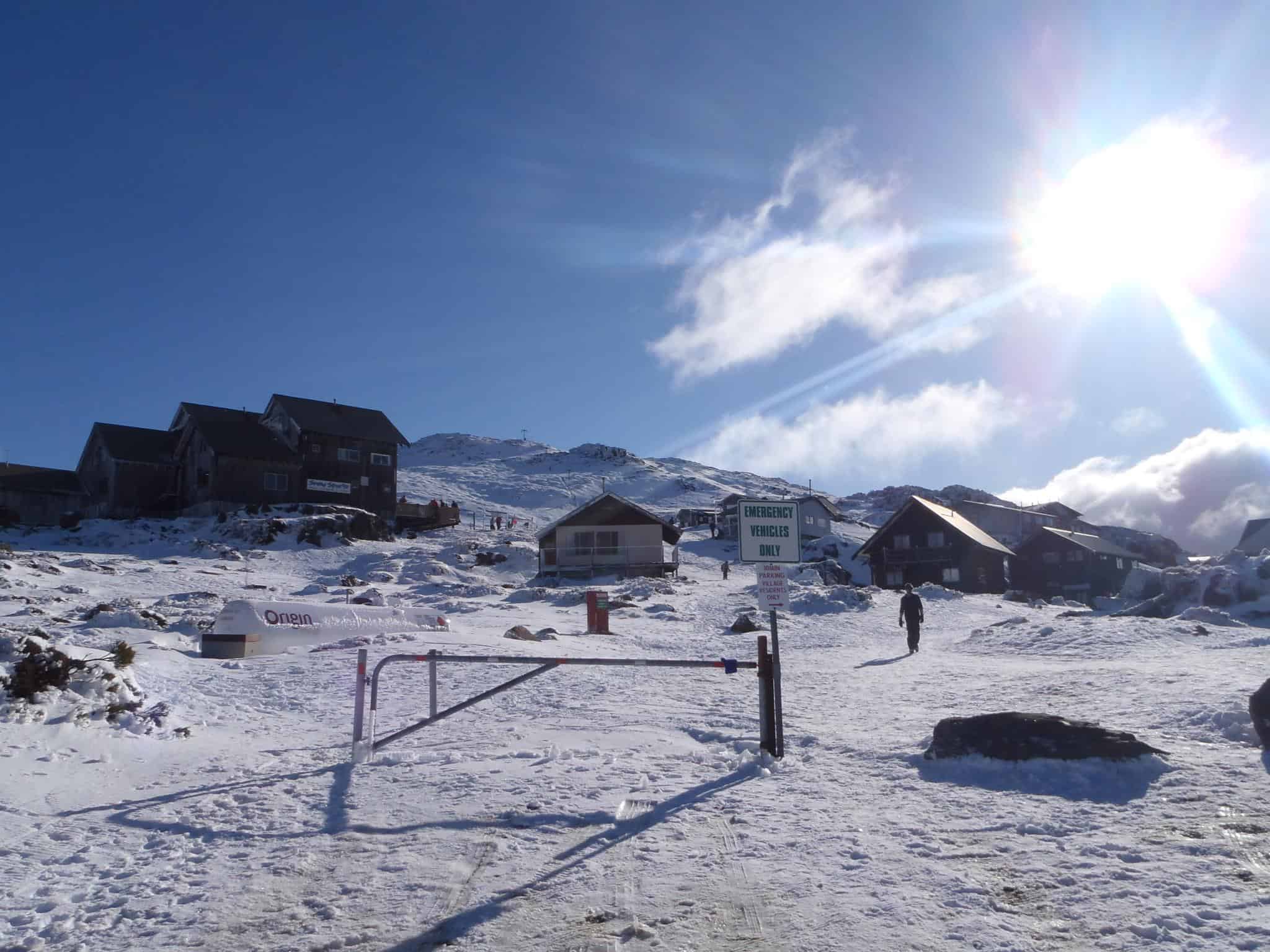 Winter sports enthusiasts enjoying at Ben Lomond ski resort in Tasmania, Australia, with a cozy chalet near a bustling winter sports center amidst stunning winter scenery.