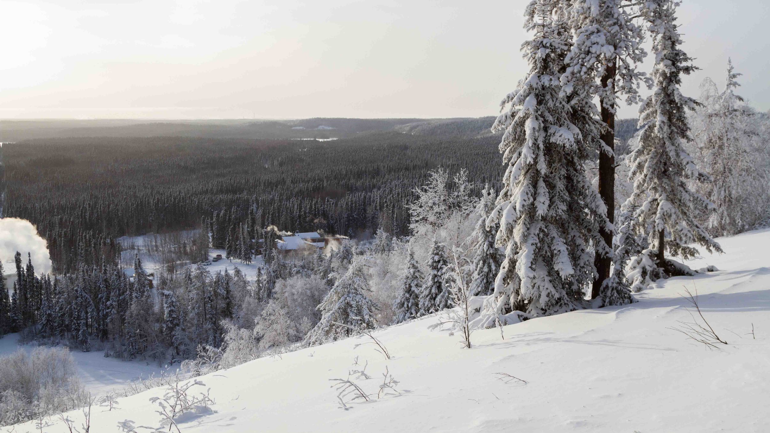 A picturesque view of the Mystery Mountain ski resort in Manitoba, Canada, showcasing a stunning winter scenery filled with snow-covered landscapes. Winter sport enthusiasts can be seen enjoying their activities.