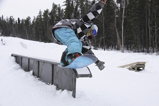 A snowboarder catching some air on the pristine slopes of Mystery Mountain in Manitoba, Canada. The crisp white snow provides a stunning contrast against the clear sky.
