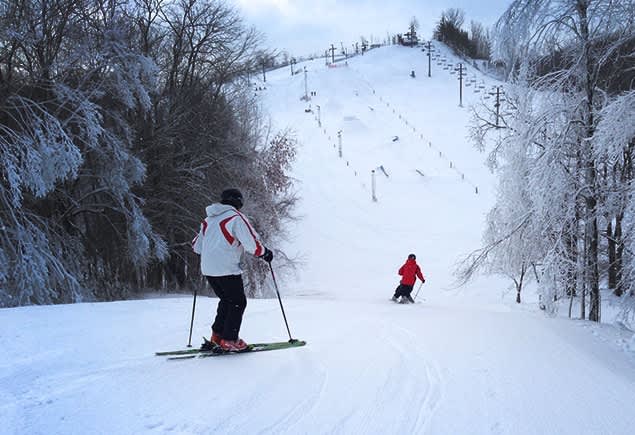 Swiss Valley in USA - two people are skiing down a snowy hill.