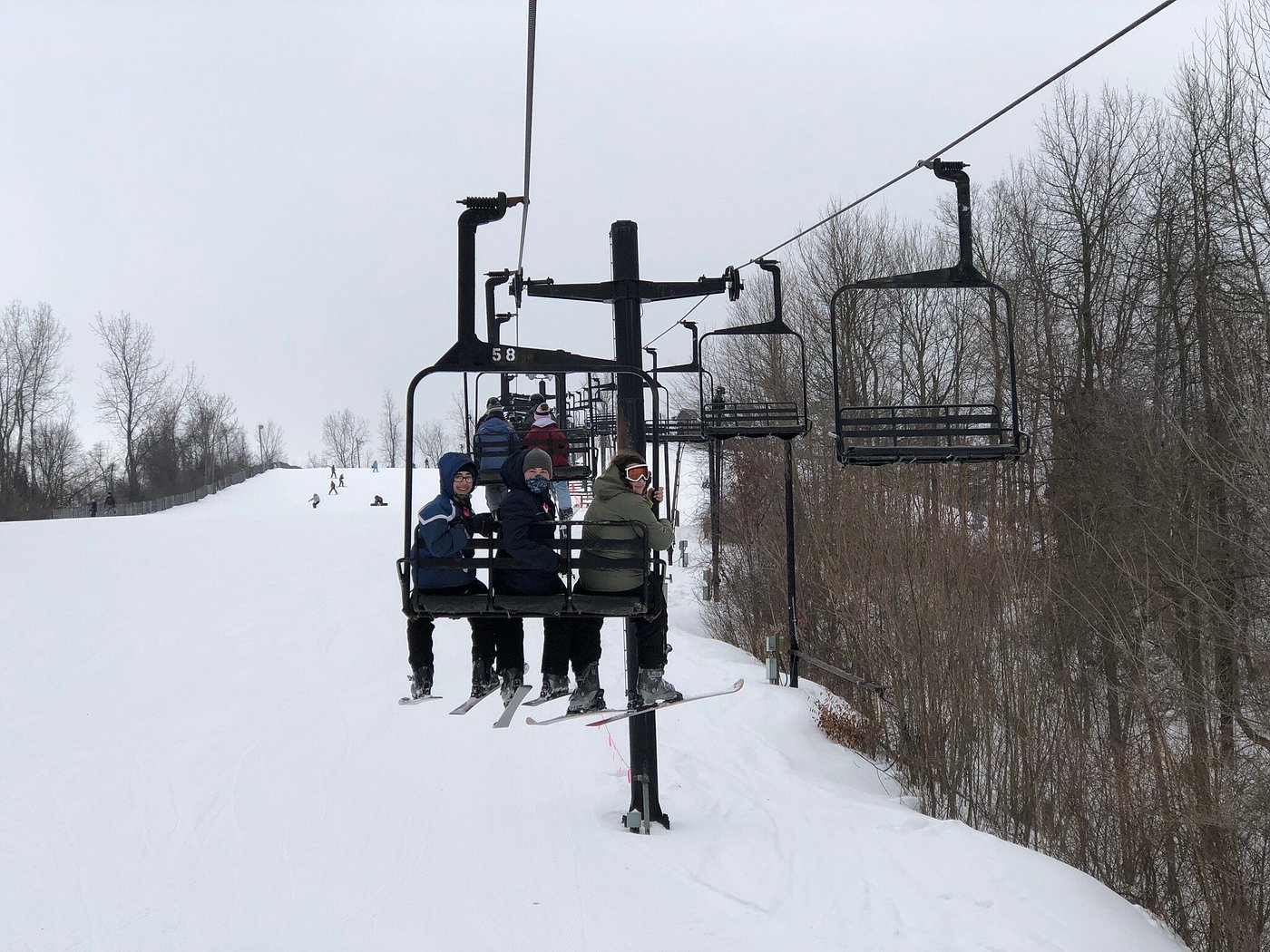 A ski lift ride at Swiss Valley Ski Resort in Michigan, USA. Skiers, including a family, take part in winter sports activities in the snowy scene.