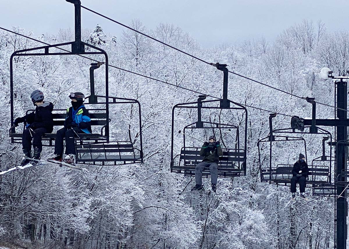 Swiss Valley in USA - a group of people riding a ski lift in the snow.