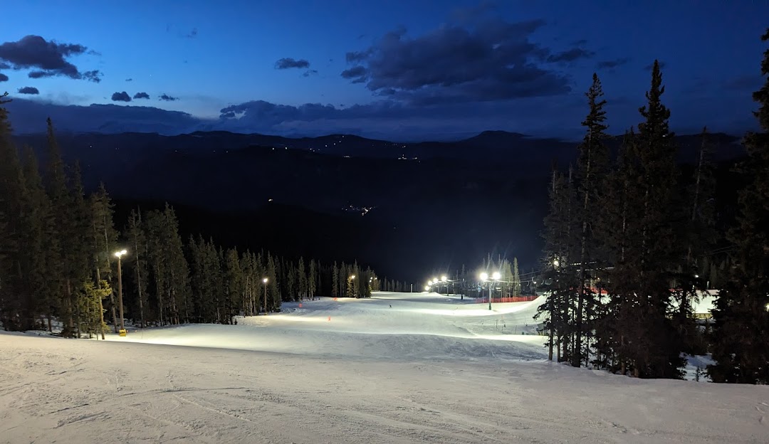 Image of Echo Mountain Park in Colorado featuring a bustling ski resort amidst stunning winter scenery. People are enjoying winter sports activities with a ski lift visible in the background.