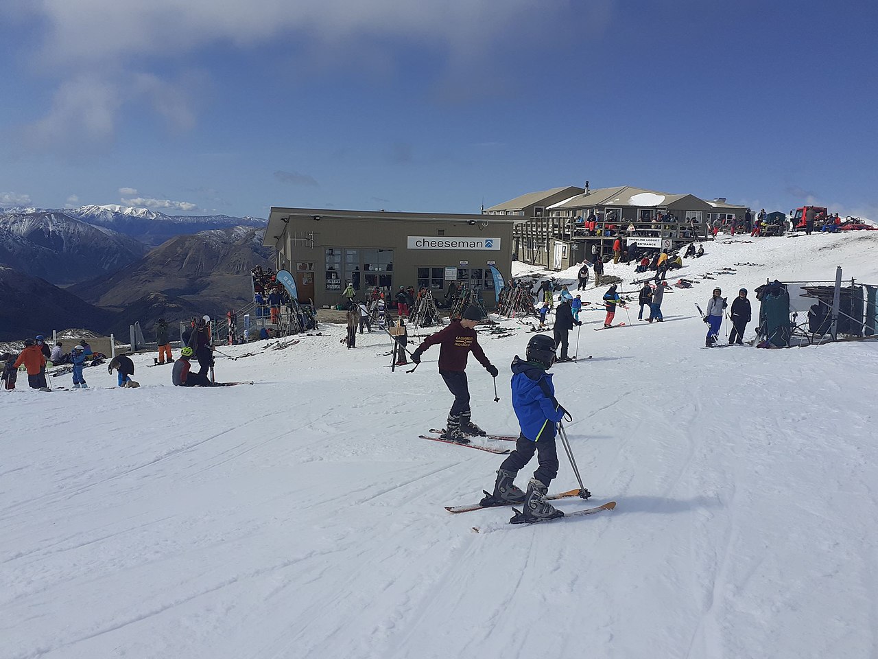 Mt Cheeseman in New Zealand - a group of people skiing down a snowy hill.