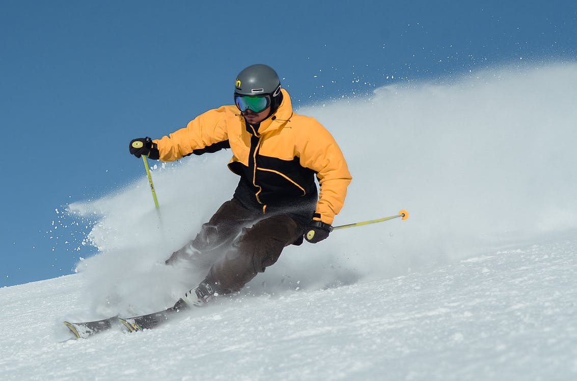 Mygovo in Ukraine - a man in a yellow jacket skiing down a hill.