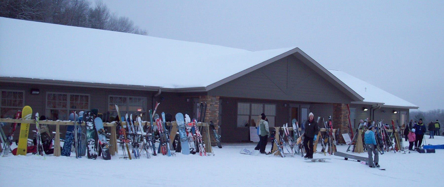 A vibrant winter sports scene at Bruce Mound Wisconsin showing numerous people enjoying skiing activities amidst a bustling ski resort.