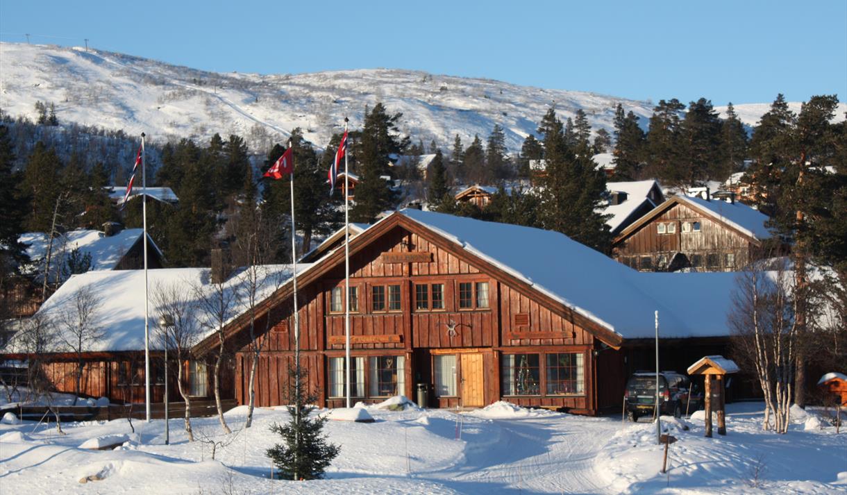 Hallbjønn in Norway - a house in the snow with mountains in the background.