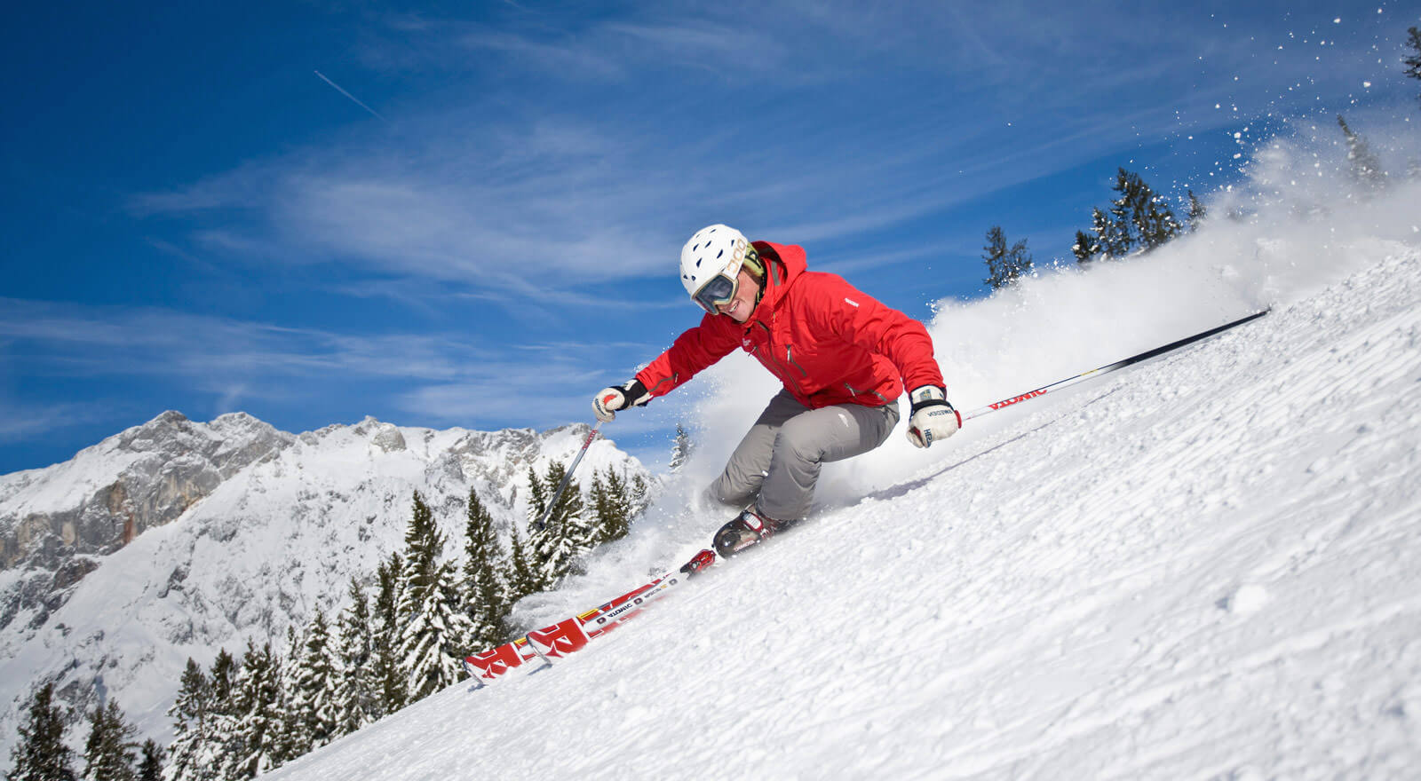Seggiovia Pian del Poggio E20 S.R.L. in Italy - a person in a red jacket skiing down a hill.