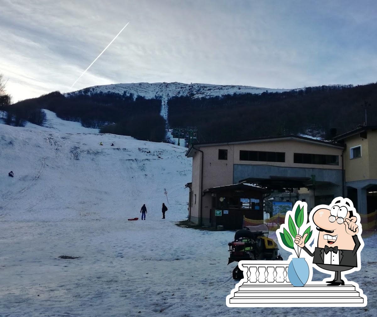 Seggiovia Pian del Poggio E20 S.R.L. in Italy: a man standing in front of a building in the snow.