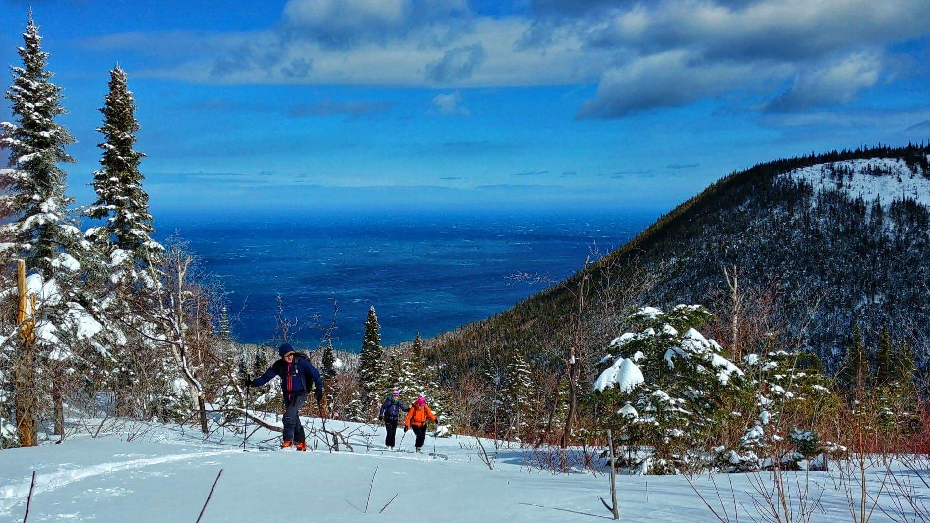 Haute Gaspésie in Canada - a group of people walking up a snow covered mountain.
