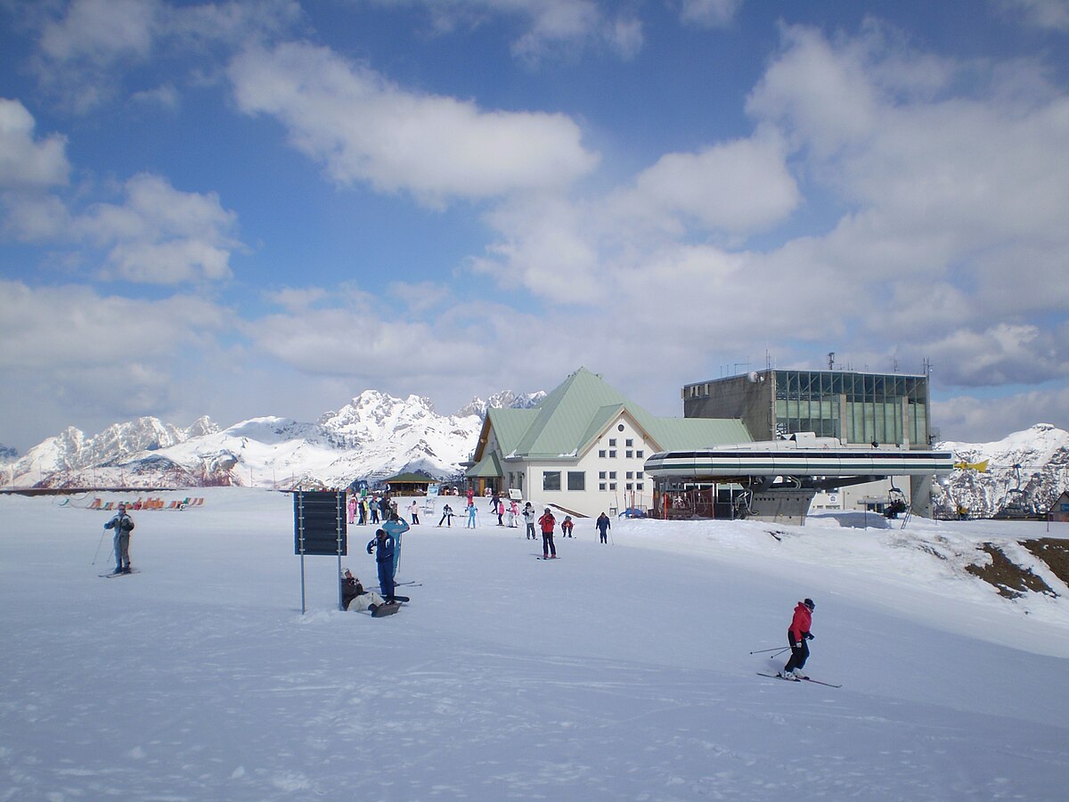 Zoncolan – Ravascletto | Sutrio in Italy - a group of people skiing down a snow covered slope.