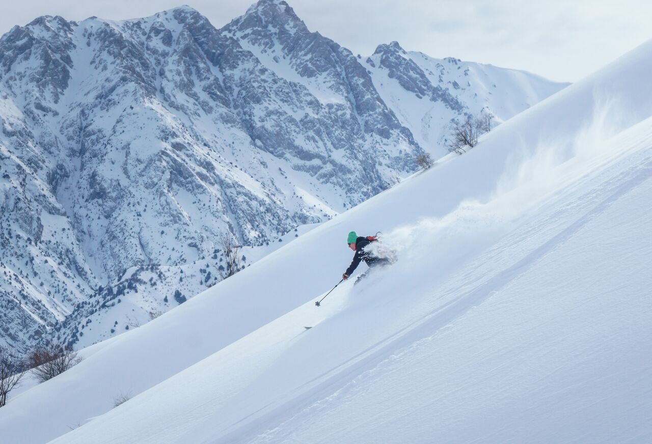 Mt Kumbel – Beldersay in Uzbekistan - a person skiing down the side of a mountain.