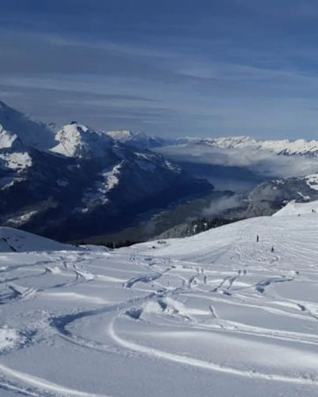 Meiringen Hasliberg in Switzerland - a person standing on top of a snow covered mountain.