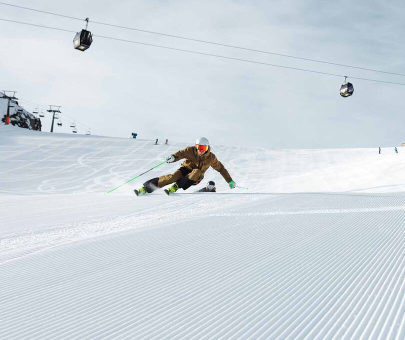 Spieljochbahn Fügen in Austria - a man riding a snowboard down a snow covered slope.