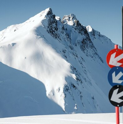 Spieljochbahn Fügen in Austria - a sign in the snow with mountains in the background.