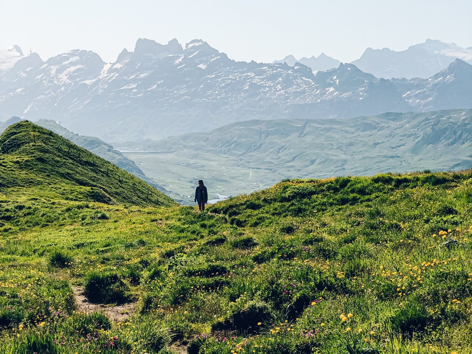 Brüsti – Attinghausen in Switzerland - a person standing on top of a green hill.