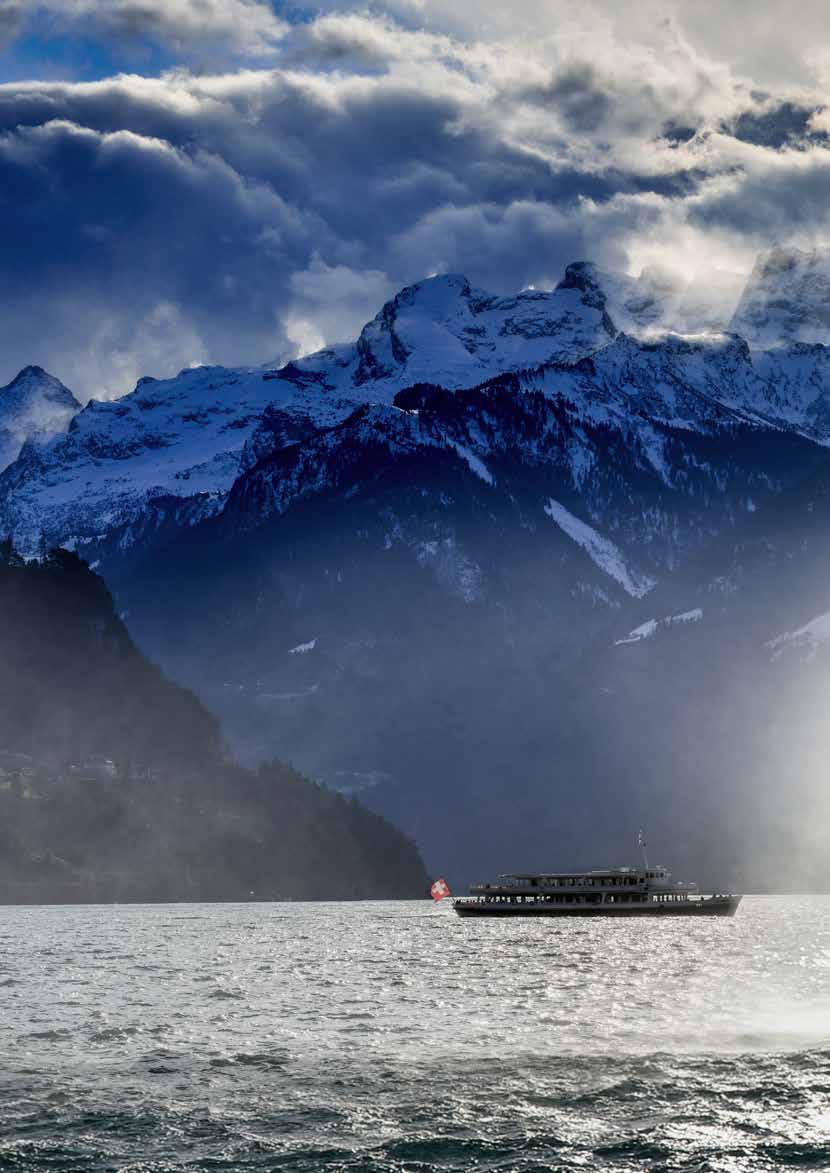 Brüsti – Attinghausen in Switzerland - a boat on the water with mountains in the background.