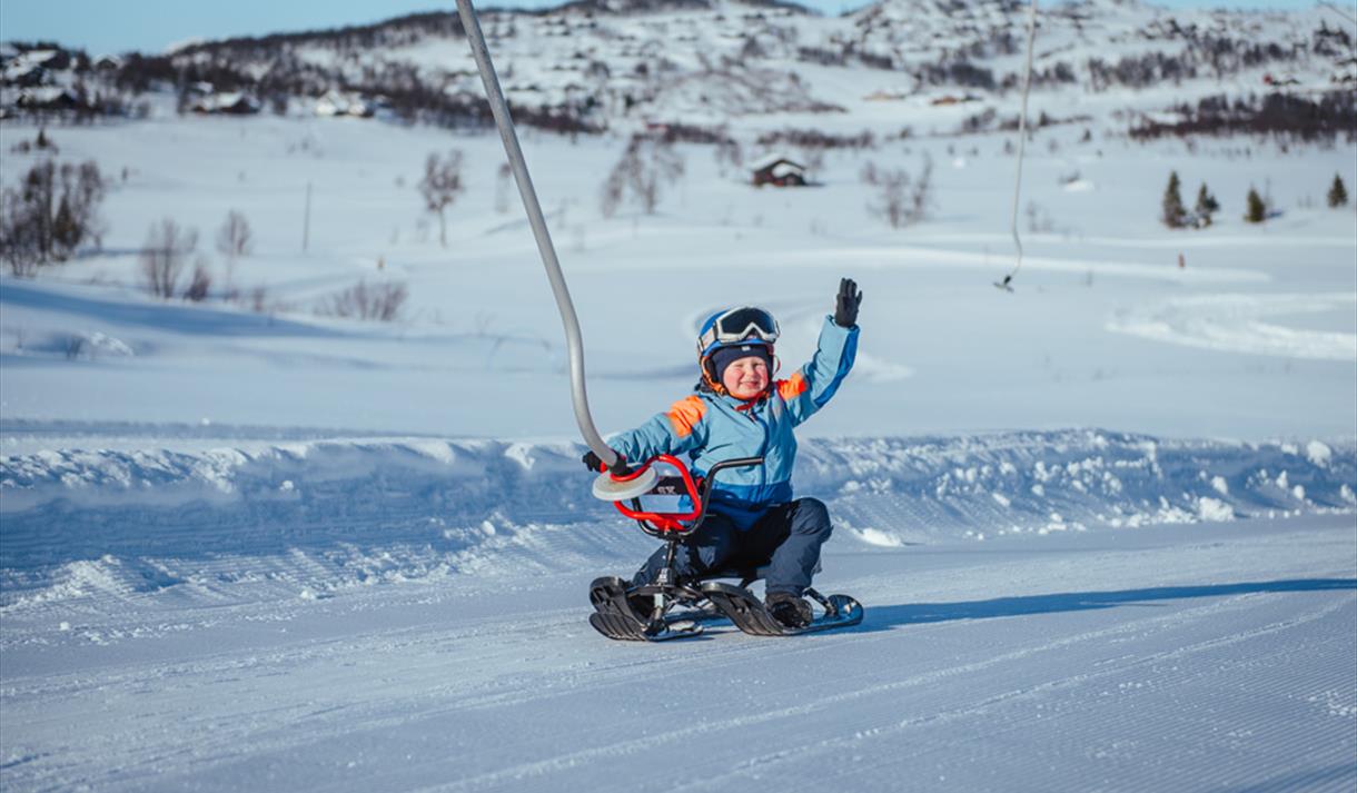 Vierli – Rauland in Norway - a child on a snowboard in the snow.