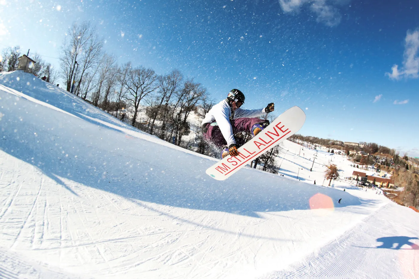 A snowboarder energetically carving down a snowy slope at Buck Hill Minnesota showcasing the thrill and daring of winter sports.