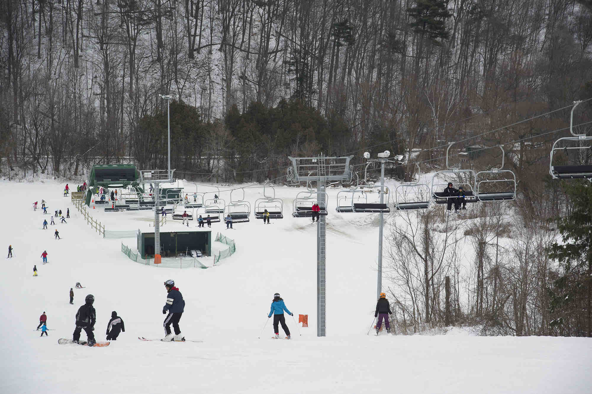Winter sports scene at Earl Bales, North York in Ontario, Canada, featuring a ski resort and ski lift with a skier in the distance.