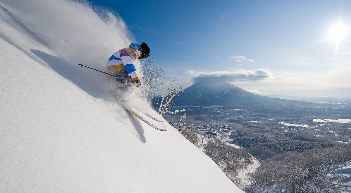 Kawachisenjo Onsen Kanazawa Seymour in Japan - a skier skiing down a snowy slope in the mountains.