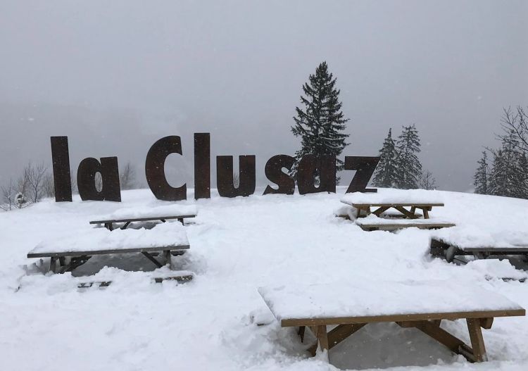 Ski resort in La Clusaz, Manigod in Savoie Mont Blanc, Auvergne-Rhône-Alpes, France. Picture showcases a bustling winter sports scene against a beautiful snowy mountain backdrop.