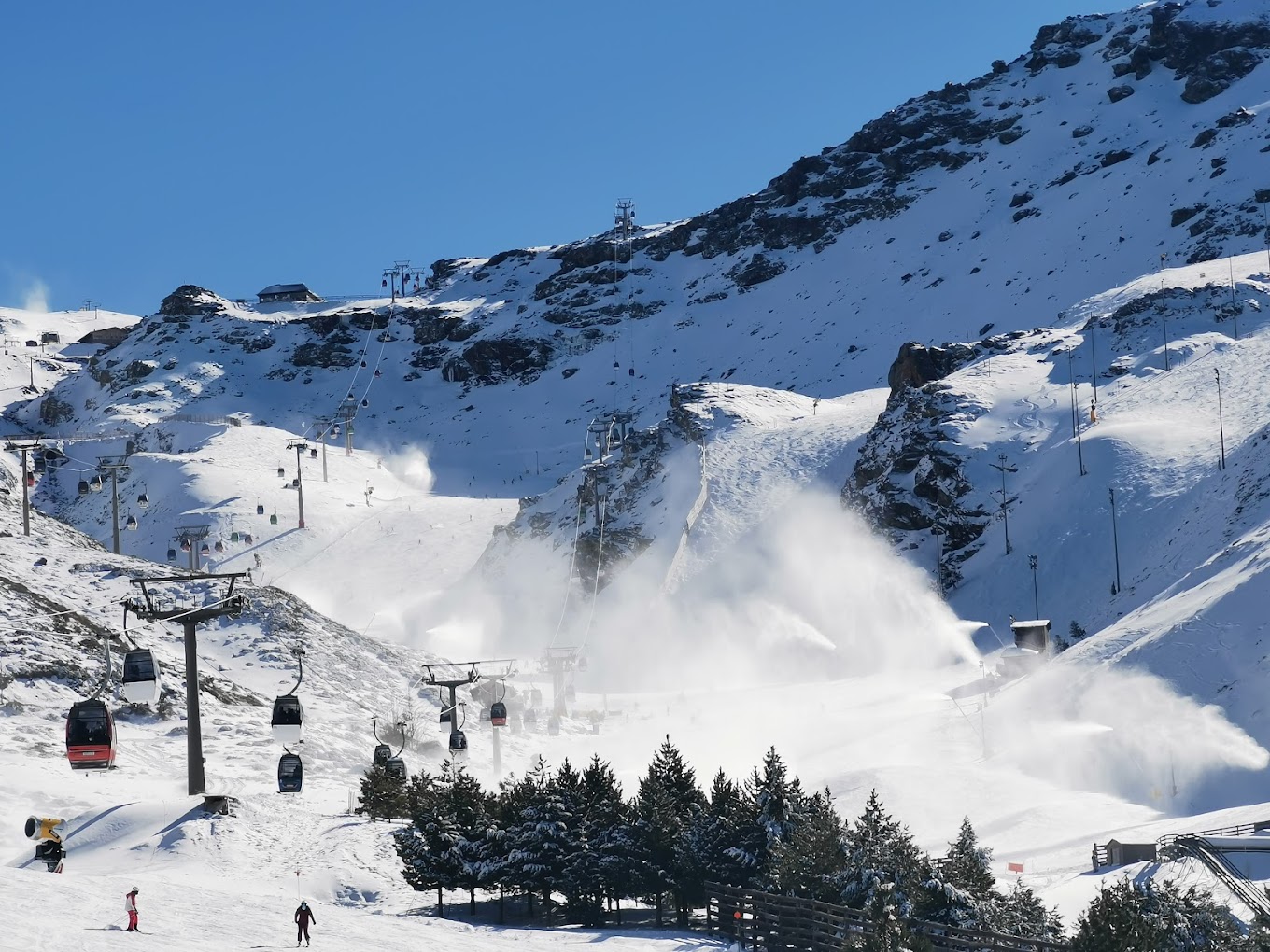 Photo of a chalet at the center of Pradollano ski resort in Sierra Nevada Spain featuring winter sports activities on snow-covered slopes.