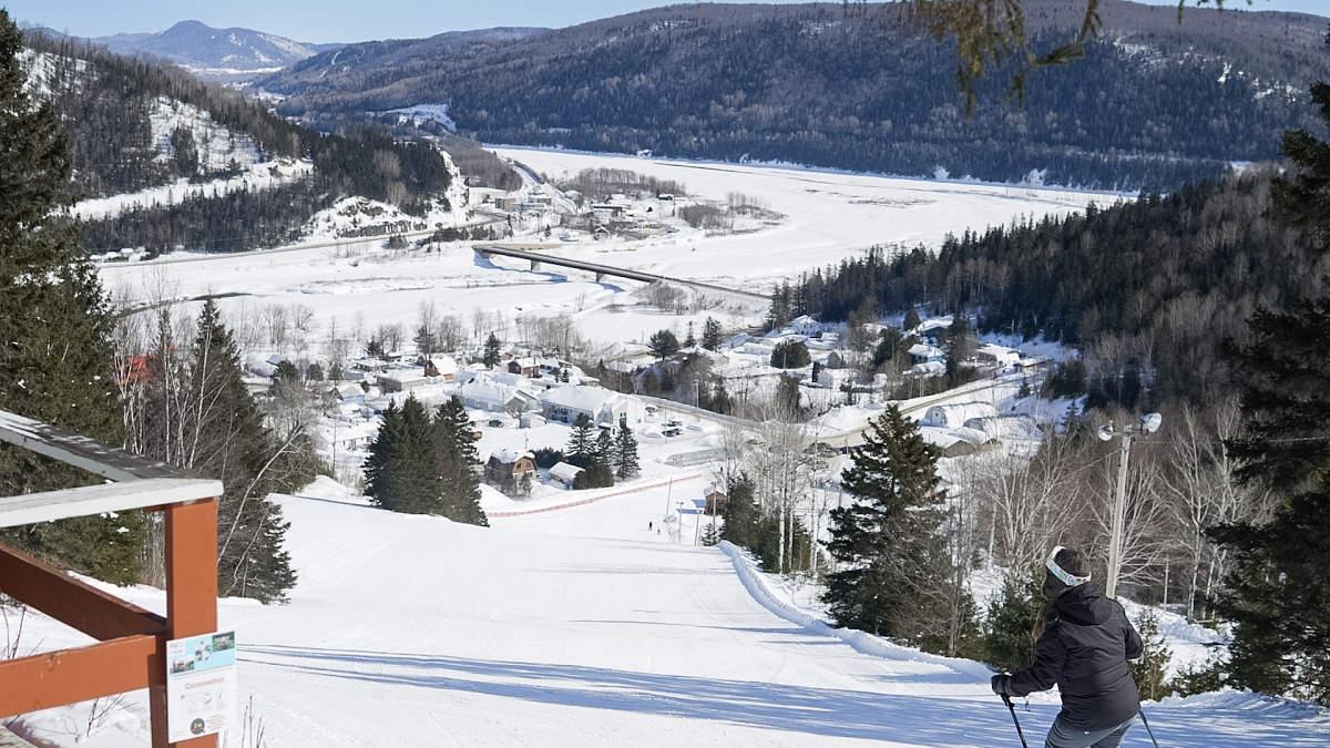Le Petit Chamonix in Canada - a person skiing down a snowy slope in the mountains.