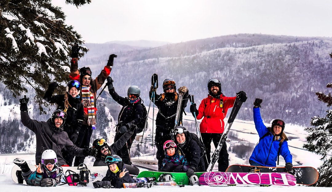 Winter sports enthusiasts enjoying a day of skiing at Le Petit Chamonix in Gaspésie–Îles-de-la-Madeleine, Quebec, with a chalet and ski resort visible.