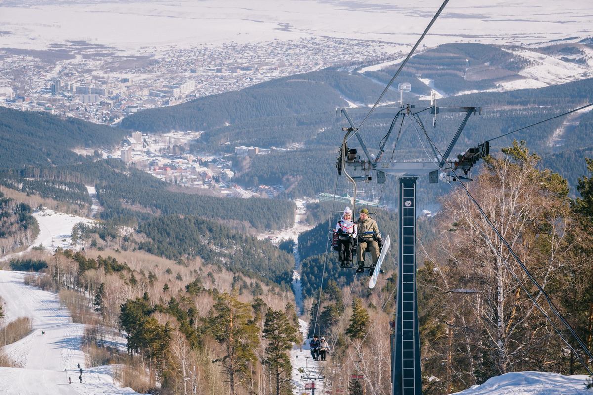 Blagodat – Belokuricha in Russia - two people on a ski lift in the mountains.