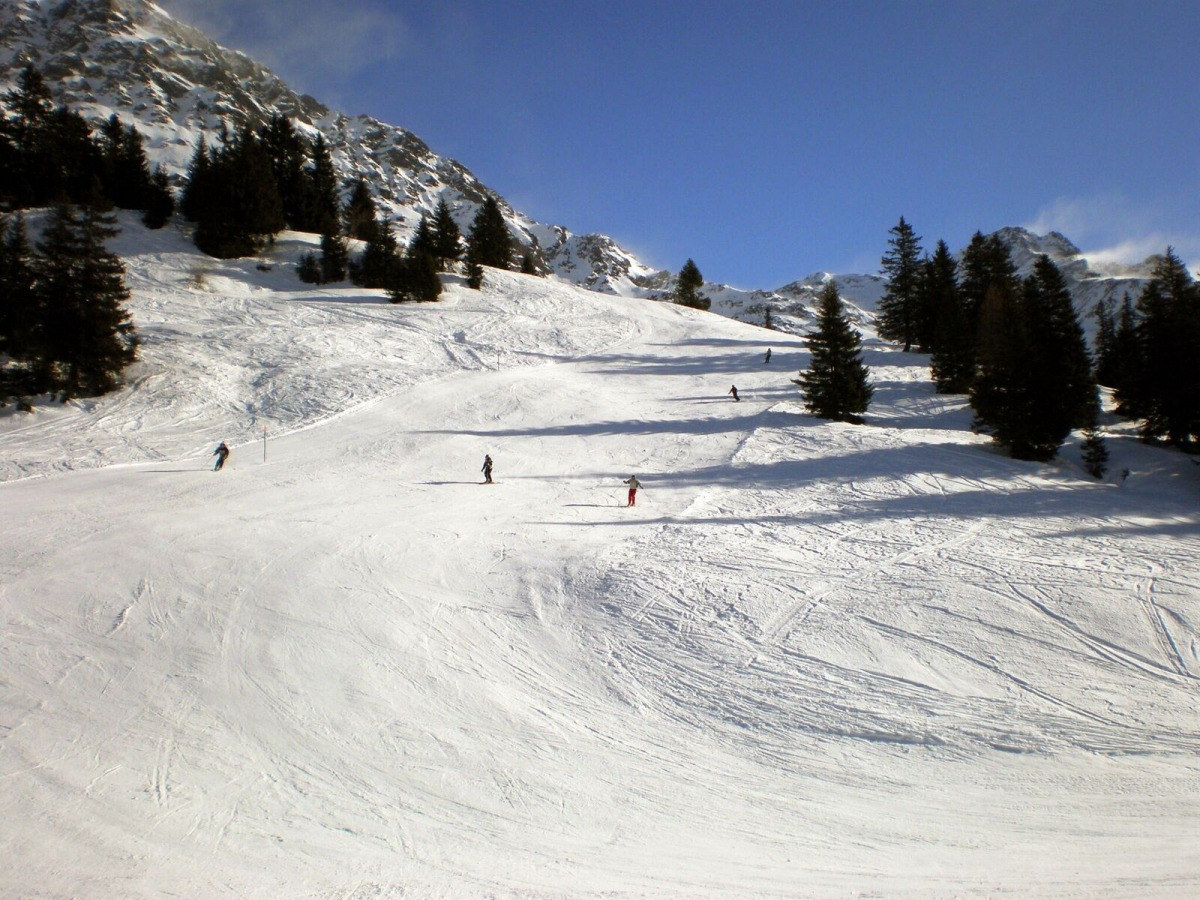 Pian Cales – San Bernardino in Switzerland - a group of people skiing down a snowy slope.