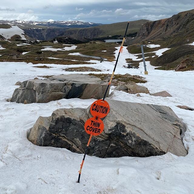 Beartooth Basin in USA - a sign sitting on top of a snow covered mountain.