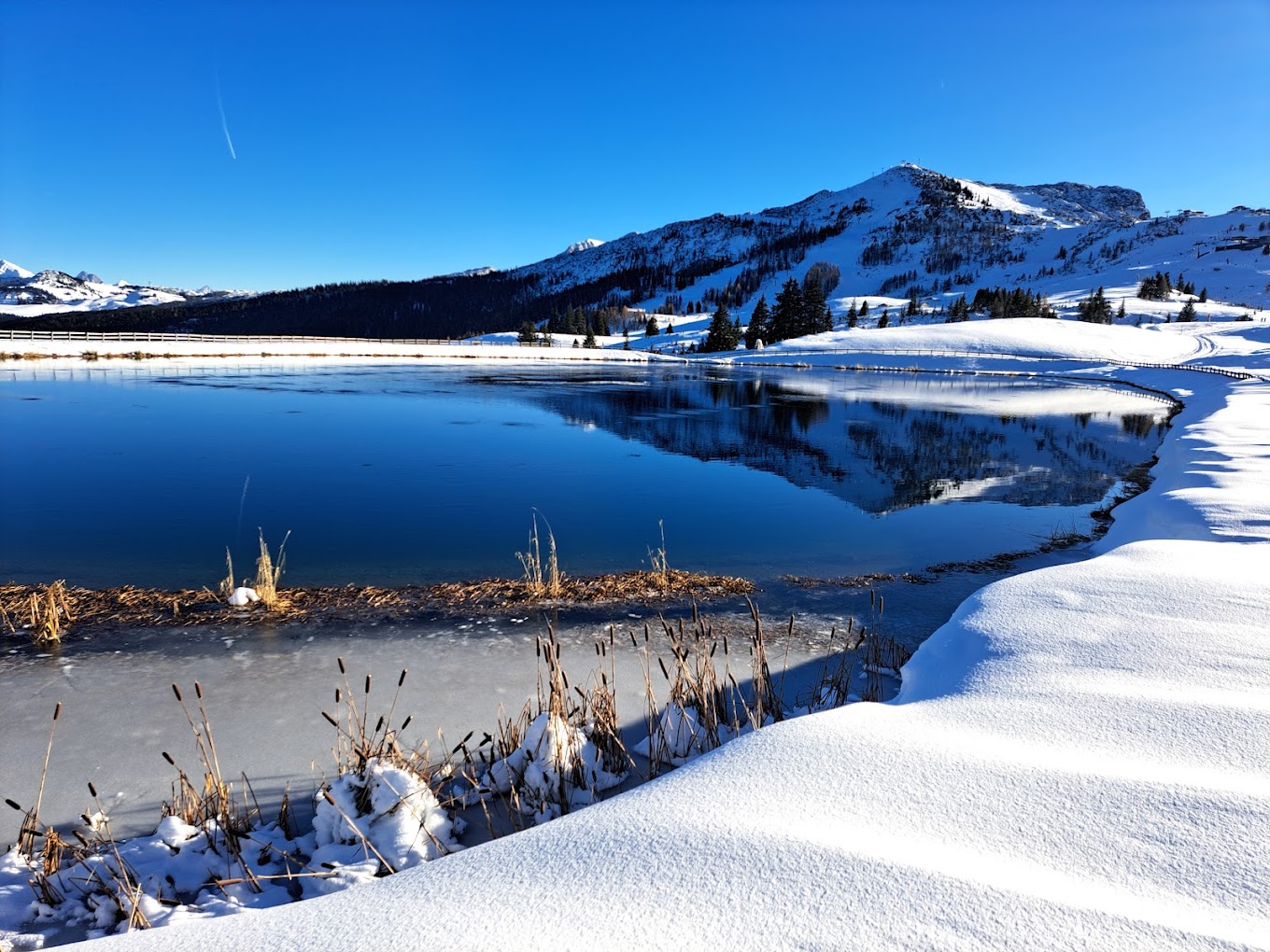 Winklmoos-Steinplatte in Austria - a lake in the snow with mountains in the background.
