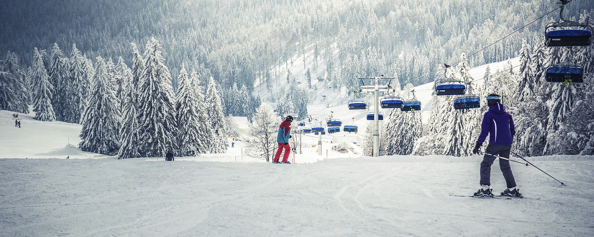 Muggenbrunn in Germany - a group of people skiing down a snowy hill.