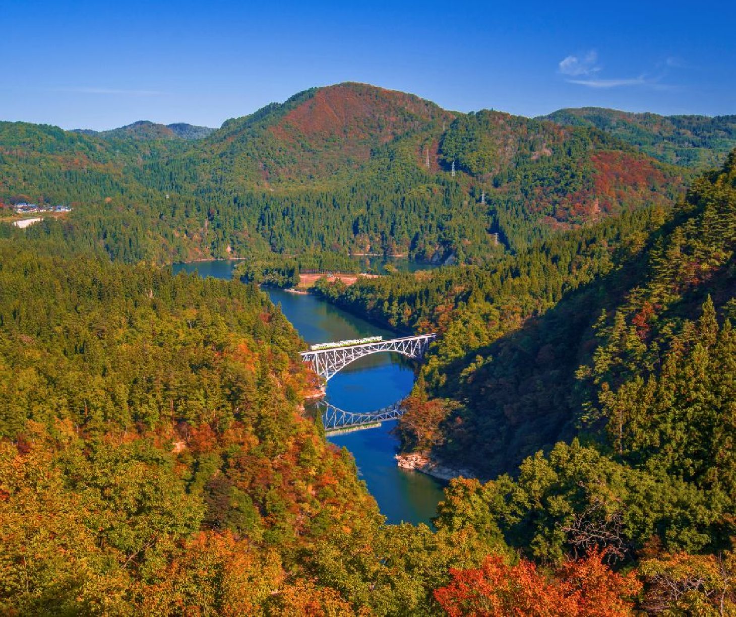 Tadami in Japan - a bridge over a river surrounded by trees.