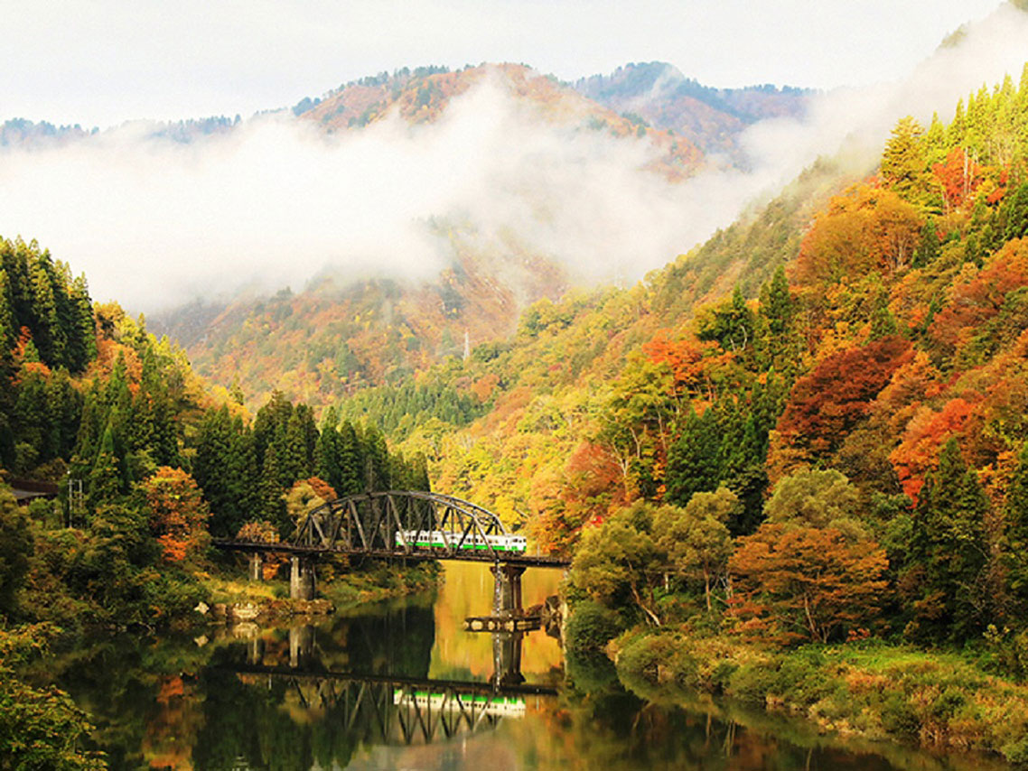 Tadami in Japan - a bridge over a river surrounded by trees.
