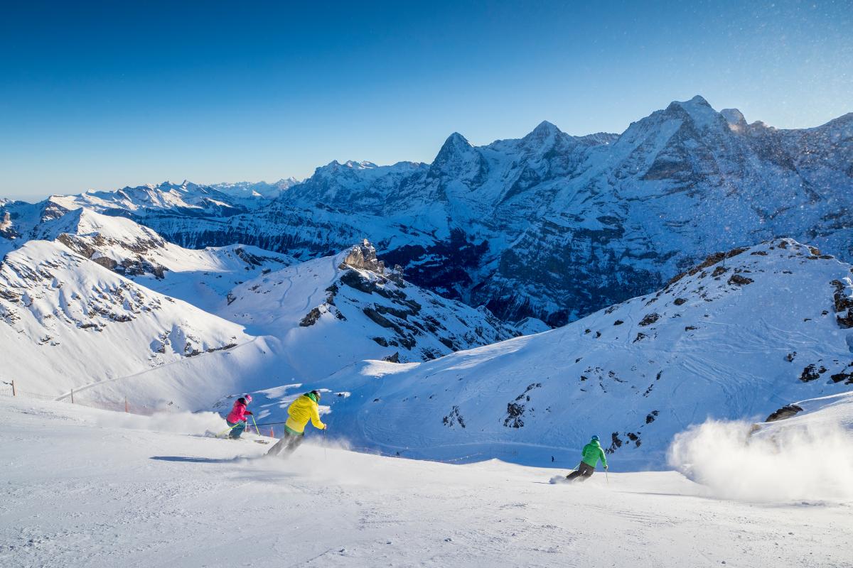 Schilthorn Murren in Switzerland - two skiers skiing down a snowy slope in the mountains.