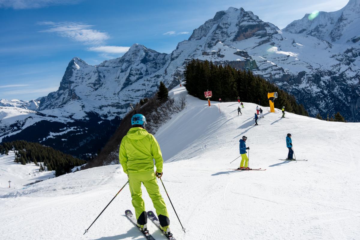 Schilthorn Murren in Switzerland - a group of people skiing down a snow covered mountain.